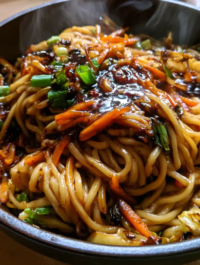 Authentic Chow Mein: The Ultimate Restaurant-Style Stir-Fry Guide 2 Detailed shot of authentic chow mein showing charred cabbage bits and dark umami sauce reflecting window light.