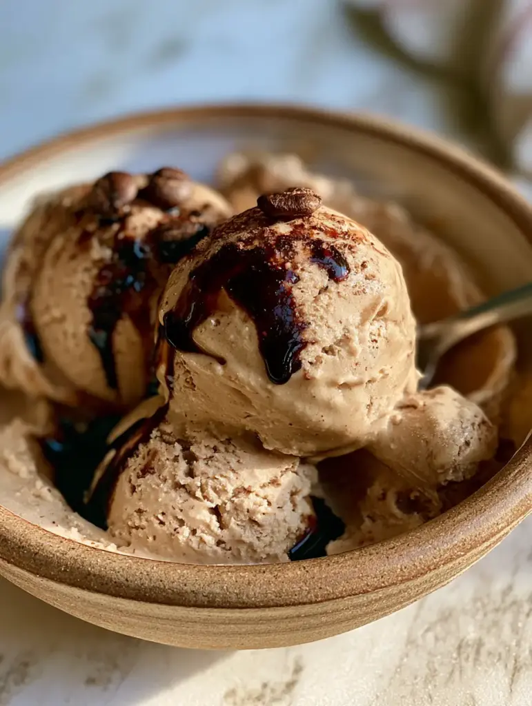 Espresso Gelato: The Ultimate Silky Italian Coffee Dessert 1 Overhead view of coffee gelato in a ceramic bowl on a marble counter.